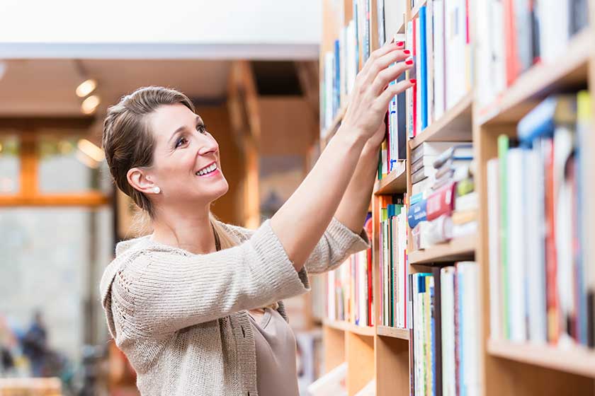 Pregnant woman reading book in bookstore