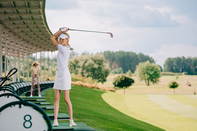 Selective focus of smiling female golfer in polo